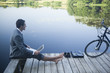 Young businessman using laptop near lake