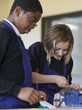 Boy and girl using vice in school workshop