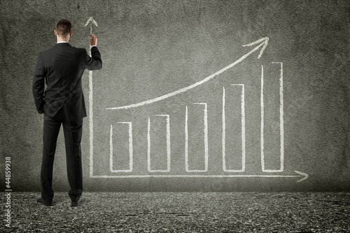Photo: businessman drawing trend chart on wall businessman drawing trend chart on wall