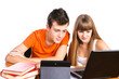 Two students learning with books and laptop sitting at table iso