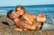 Sexy couple laying on pebble beach.