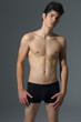 sexy handsome muscular young man on gray background