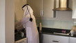 Saudi Arabian man washing dishes at home