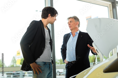 Photo: Man buying car from salesperson Man buying car from salesperson