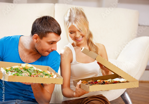 Photo: romantic couple eating pizza at home romantic couple eating pizza at home