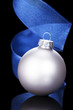 silberne christbaumkugel mit blauem stoffband