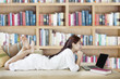 Photo: Woman with laptop in library Woman with laptop in library
