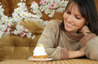 Happy Caucasian woman sitting at a table with a cake