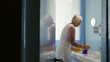 Active retired woman doing chores and cleaning bathroom at home