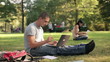 Young student with laptop in the park, steadicam shot
