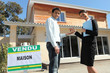 Female estate agent stood outside house with customer