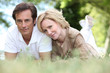 A loving couple lying on the grass