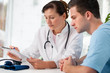 Ärztin berät einen jungen Patienten