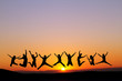silhouette of friends jumping in sunset for fun