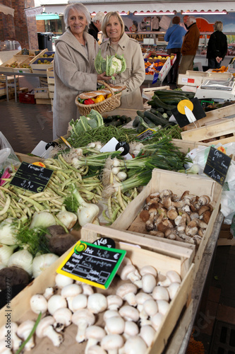 Photo: Two women shopping at vegetable market Two women shopping at vegetable market