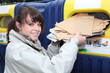 Woman using paper recycling bin