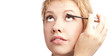 Young blonde does make-up. Studio