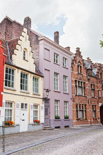Photo: European small street with old brick houses. Bruges. Belgium. European small street with old brick houses. Bruges. Belgium.