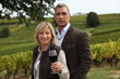Married couple in vineyard sampling wine