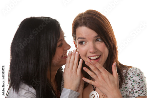 Photo: Zwei junge Frauen tuscheln miteinander Zwei junge Frauen tuscheln miteinander