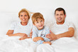 Familie liegt am Morgen im Bett
