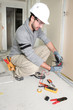 Photo: Man snipping wall wiring Man snipping wall wiring