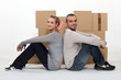 Couple sitting in front of cardboard boxes