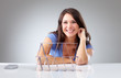Smiling young woman with a house of cards