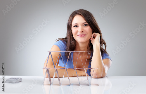 Photo: Proudly young woman with a house of cards Proudly young woman with a house of cards