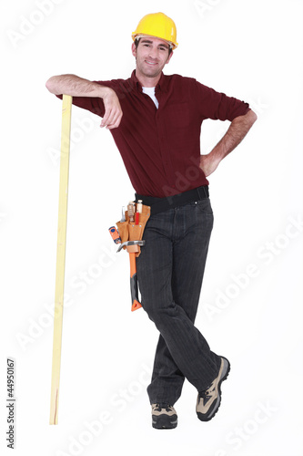 Photo: Construction worker with a piece of timber Construction worker with a piece of timber
