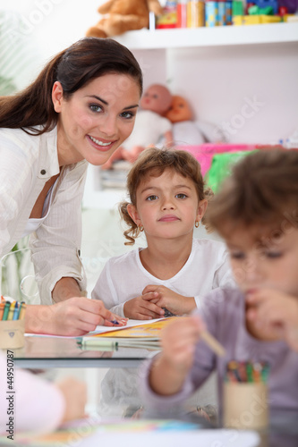 Photo: Young teacher and children in a classroom Young teacher and children in a classroom