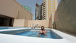 man in swimming pool at roof of apartment in Bahrain