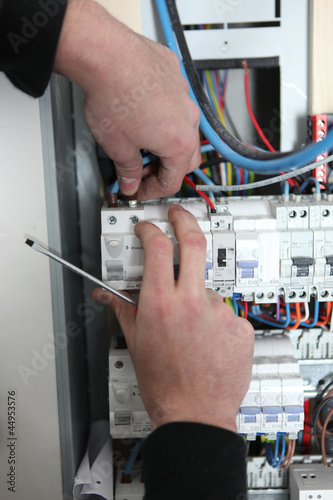 Photo: Man at a fuse box Man at a fuse box