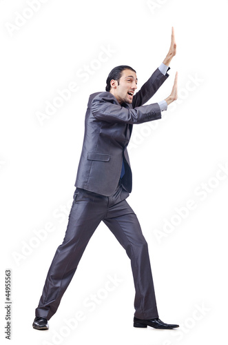 Photo: Young businessman pushing invisible obstacles Young businessman pushing invisible obstacles