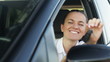 Female driver in a car showing the car key
