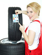 Female car mechanic showcases tire label on white background