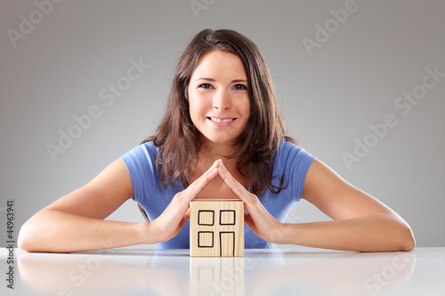 Photo: Young smiling woman make a roof with hands, symbolical Young smiling woman make a roof with hands, symbolical