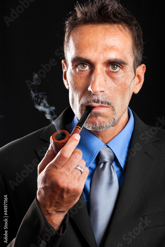 Photo: Fashion portrait of a businessman smoking a tobacco pipe Fashion portrait of a businessman smoking a tobacco pipe