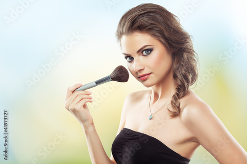 Photo: Woman with a make-up brush Woman with a make-up brush