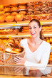 Bäckerin verkauft Brot im Korb in Bäckerei