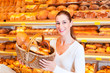 Bäckerin verkauft Brot im Korb in Bäckerei