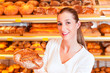 Bäckerin in ihrer Bäckerei verkauft Brot
