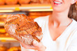 Bäckerin in ihrer Bäckerei verkauft Brot