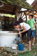Mother and son getting water from well