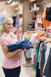 Photo: Woman standing holding pants Woman standing holding pants
