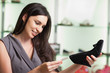 Photo: Woman looking at price tag of shoe and smiling Woman looking at price tag of shoe and smiling