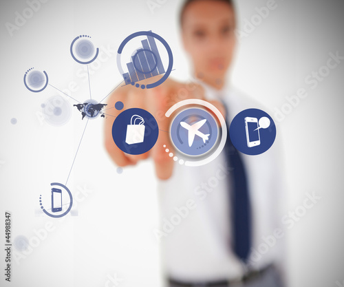 Photo: Businessman selecting airplane symbol from digital menu Businessman selecting airplane symbol from digital menu