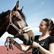 Pretty woman proudly presents her horse outdoors