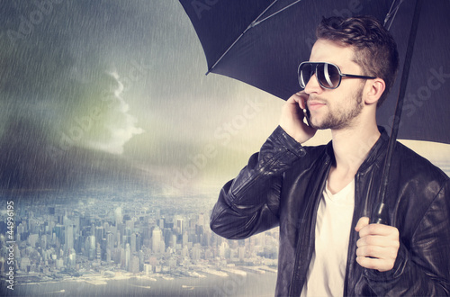 Photo: Man talking on his cellphone in the rain Man talking on his cellphone in the rain