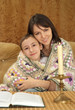 Beautiful nice Caucasian mom with her boy reading a book